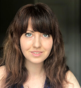 A young woman with brown hair and green eyes.