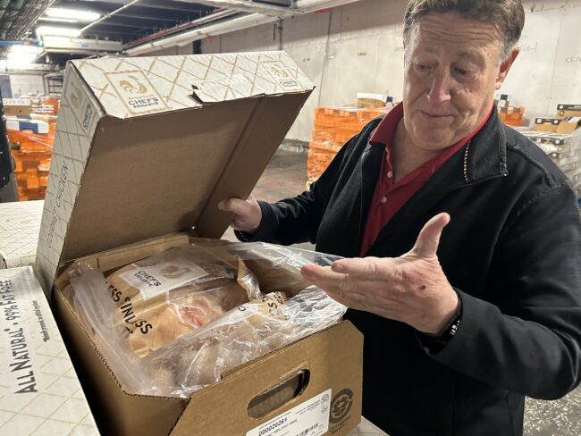The Rising Threat to New York City’s Food System – State of the Planet Man showing chicken breasts that are packed and ready to go.