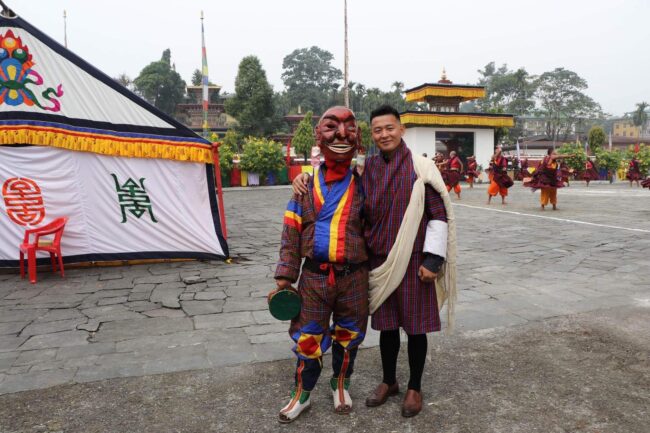 Siswa Chimi Dorji di Bhutan berdiri di samping orang-orang yang memakai masker