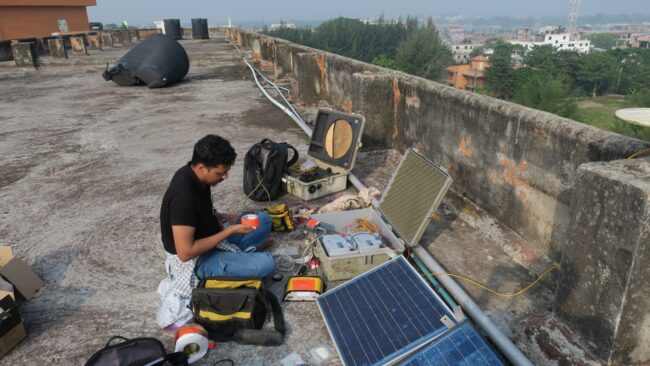 Seorang insinyur bekerja untuk memperbaiki peralatan di atap