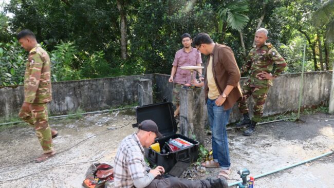 Orang-orang memperbaiki sistem satelit navigasi global dengan pengawalan militer