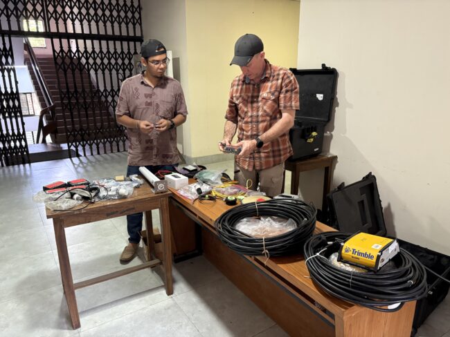 Dua orang bekerja untuk mengatur peralatan