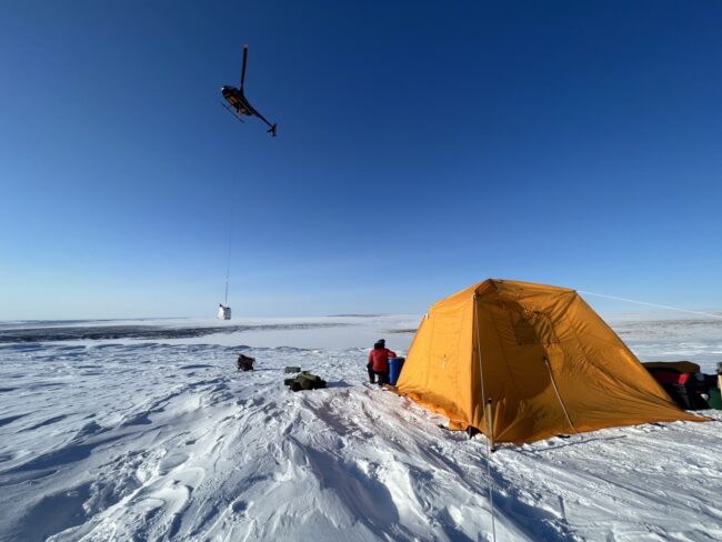 An orange tent set up on the Greenland ice sheet