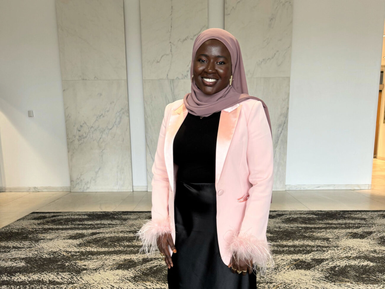Woman in head scarf and pink jacket