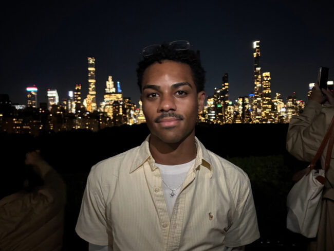 Zachary Desrosiers-Victorin di depan cakrawala kota pada malam hari