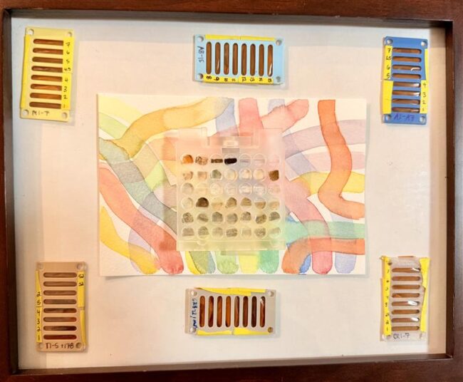 A series of trays containing representative samples of subducting sediment packages that span the Pacific Ring of Fire, wrapped in tiny x-ray tape tubes, and pressed into a 3D printed 8-slot sample holder.