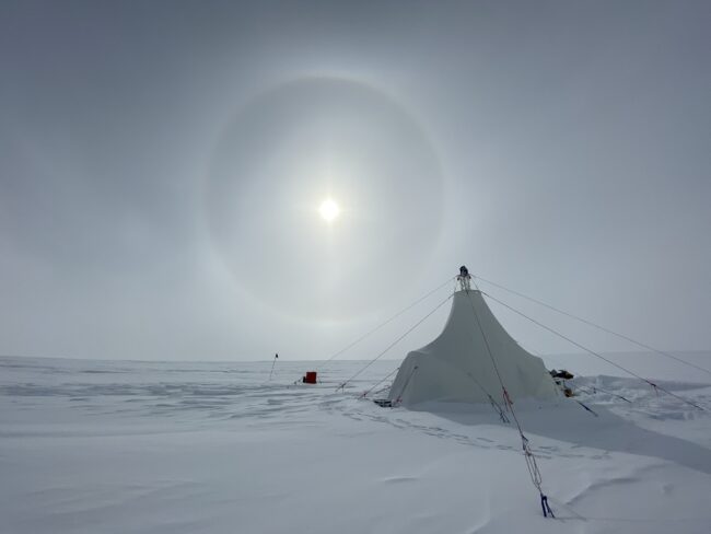 A white drill tent at the Allan Hills Blue Ice Area in East Antarctica, with a large sun halo