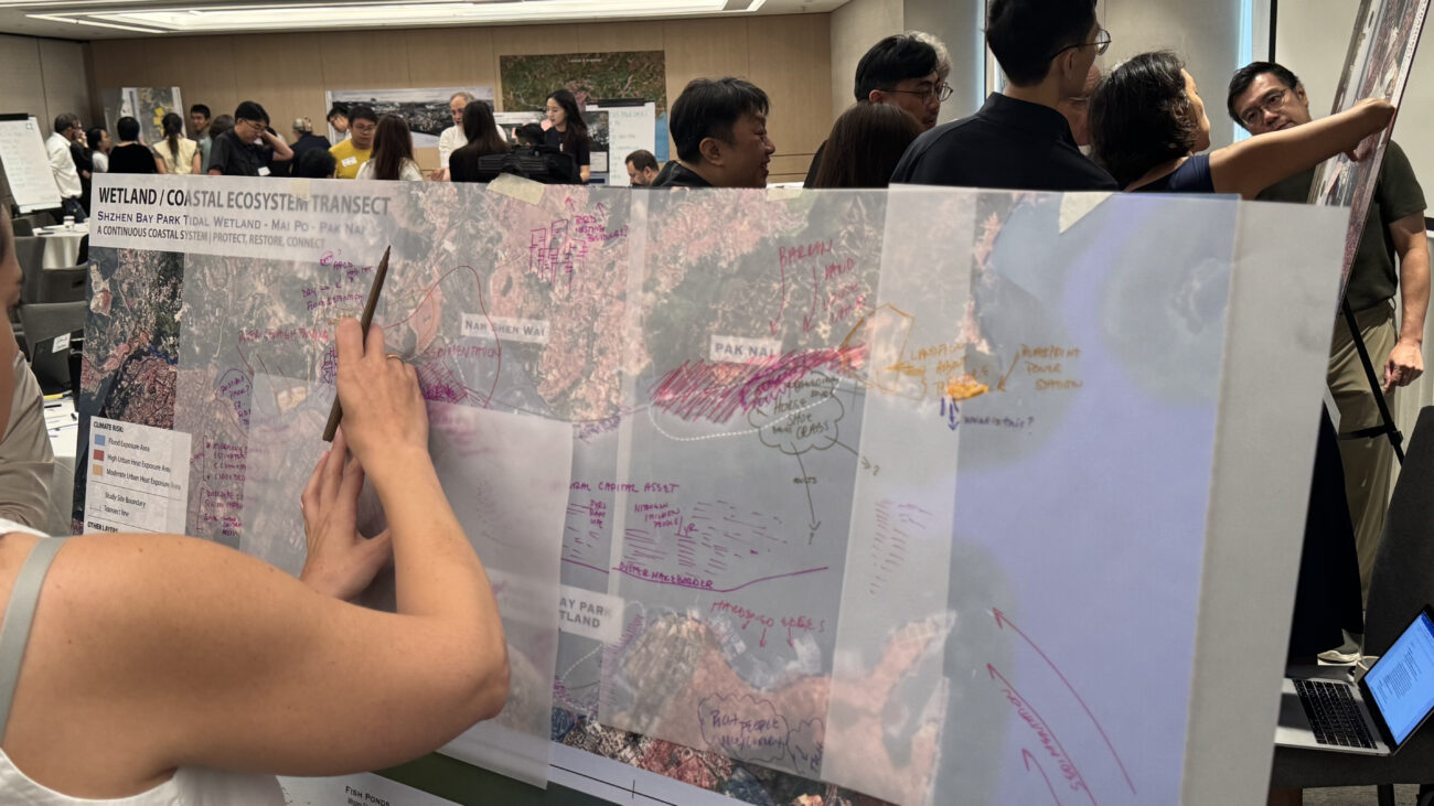 People collaborating around a large annotated wetland and coastal ecosystem map in a workshop