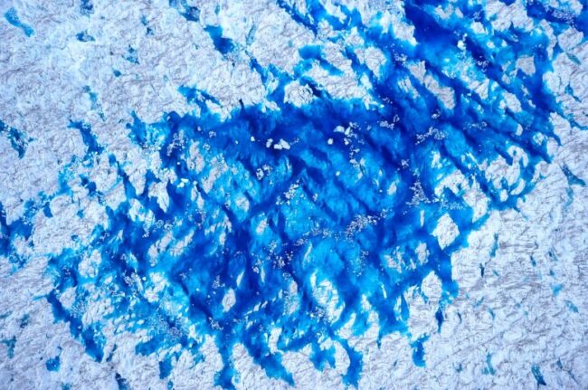 Abstract blue and white textured pattern resembling ice or water, taken from a drone