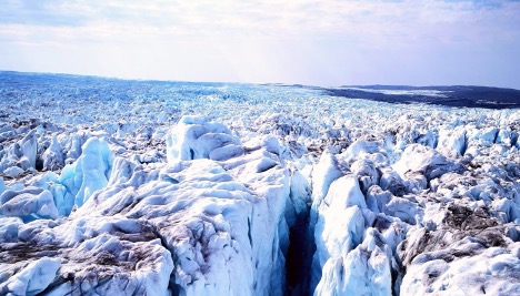 Glacier ice with deep crevasses stretching toward the horizon