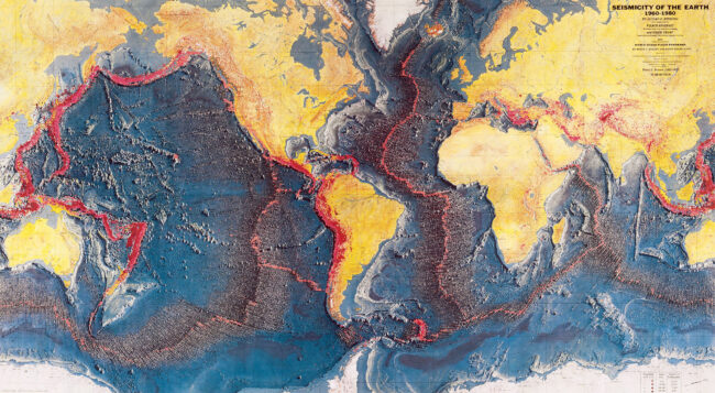 A version of the World Ocean Floor map with earthquakes plotted in red, which trace mid-ocean ridges and tectonic plate boundaries.