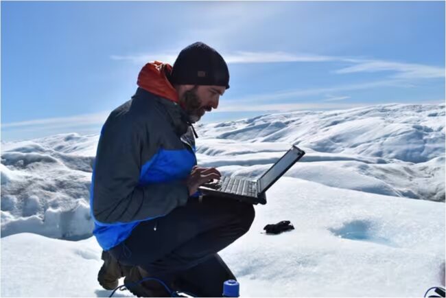 Marco Tedesco on a laptop on the Russell Glacier