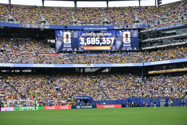 Packed soccer stadium with a FIFA World Cup 2026 scoreboard announcing a world-record attendance of 3,605,357