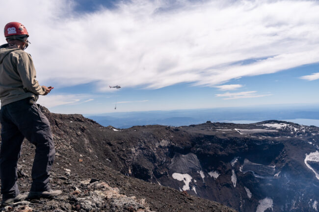 Each day, the helicopter would make nearly a dozen trips from the base camp to the rim, hauling everything from cement bags to heavy equipment, tools, solar panels, and the 32 lead-acid batteries that would provide continuous power to the instruments. Photo by Francesco Fiondella