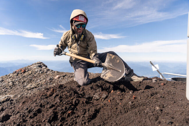 de Moor digs a hole for one of the concrete pilings that will support the frame of solar  panels. The panels will recharge an array of batteries that power the multigas sensor. Photo by Francesco Fiondella.