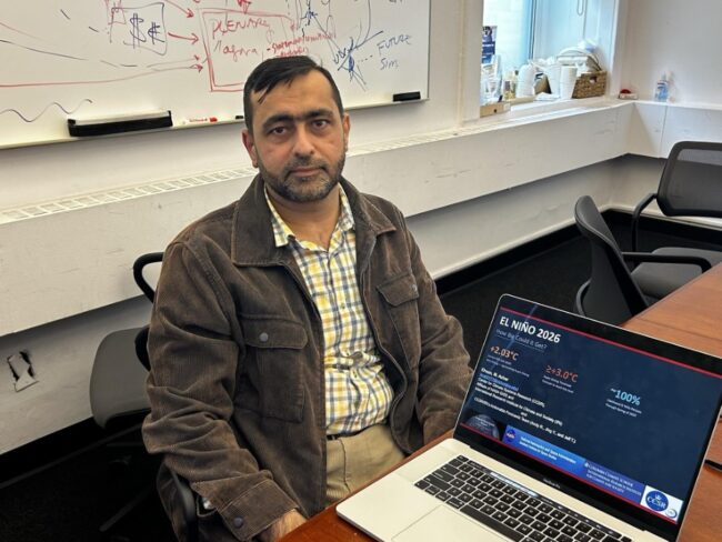 El Nino researcher Muhammad Azhar Ehsen sitting in office, next to a laptop 
